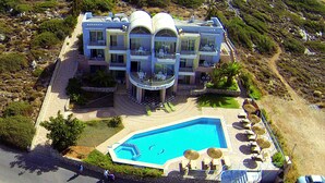 Un hôtel à plusieurs étages doté d’une piscine, d’un espace extérieur aménagé et d’un jardin paysager.