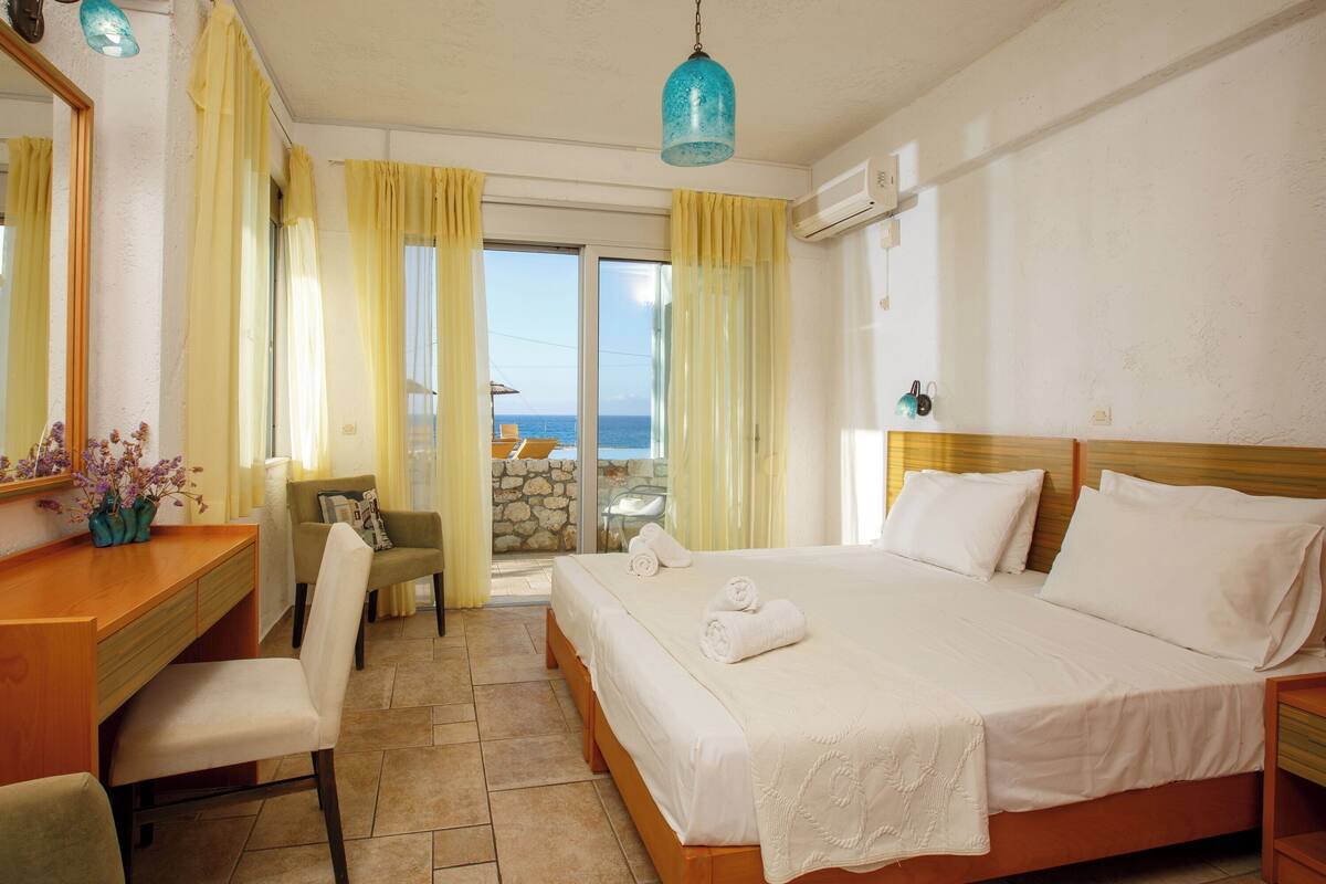 Ein Hotelzimmer mit Bett, Schreibtisch, Stuhl und Meerblick.