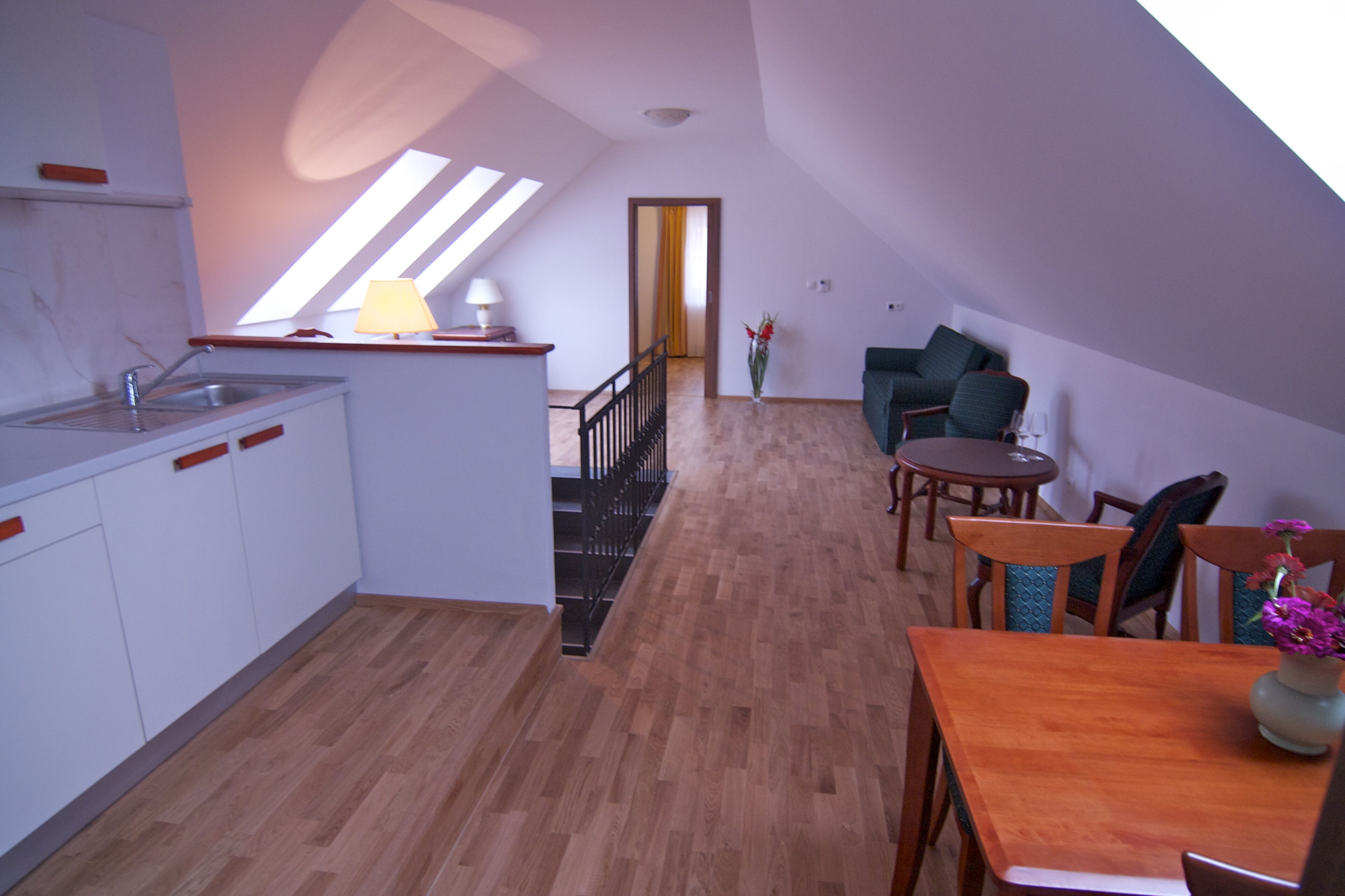 Ein geräumiges Loft mit Küche, Essbereich und einer Treppe zu einer oberen Ebene.
