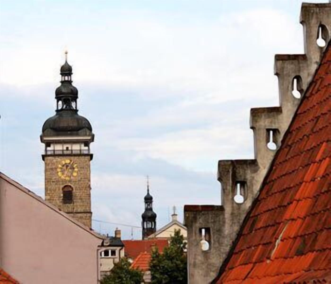 Ein historisches Gebäude mit einem Glockenturm und einem roten Ziegeldach.