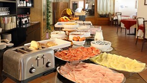 A buffet table with various food items including bread, ham, cheese, and eggs. - Hotel Santa Caterina (Valfurva)