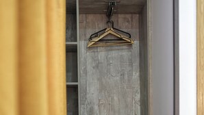 Una habitación con pared de madera, una silla negra y un perchero.