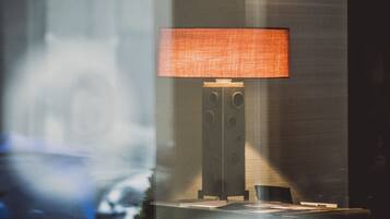A modern lamp with a rectangular shade on a stand, positioned against a wall.