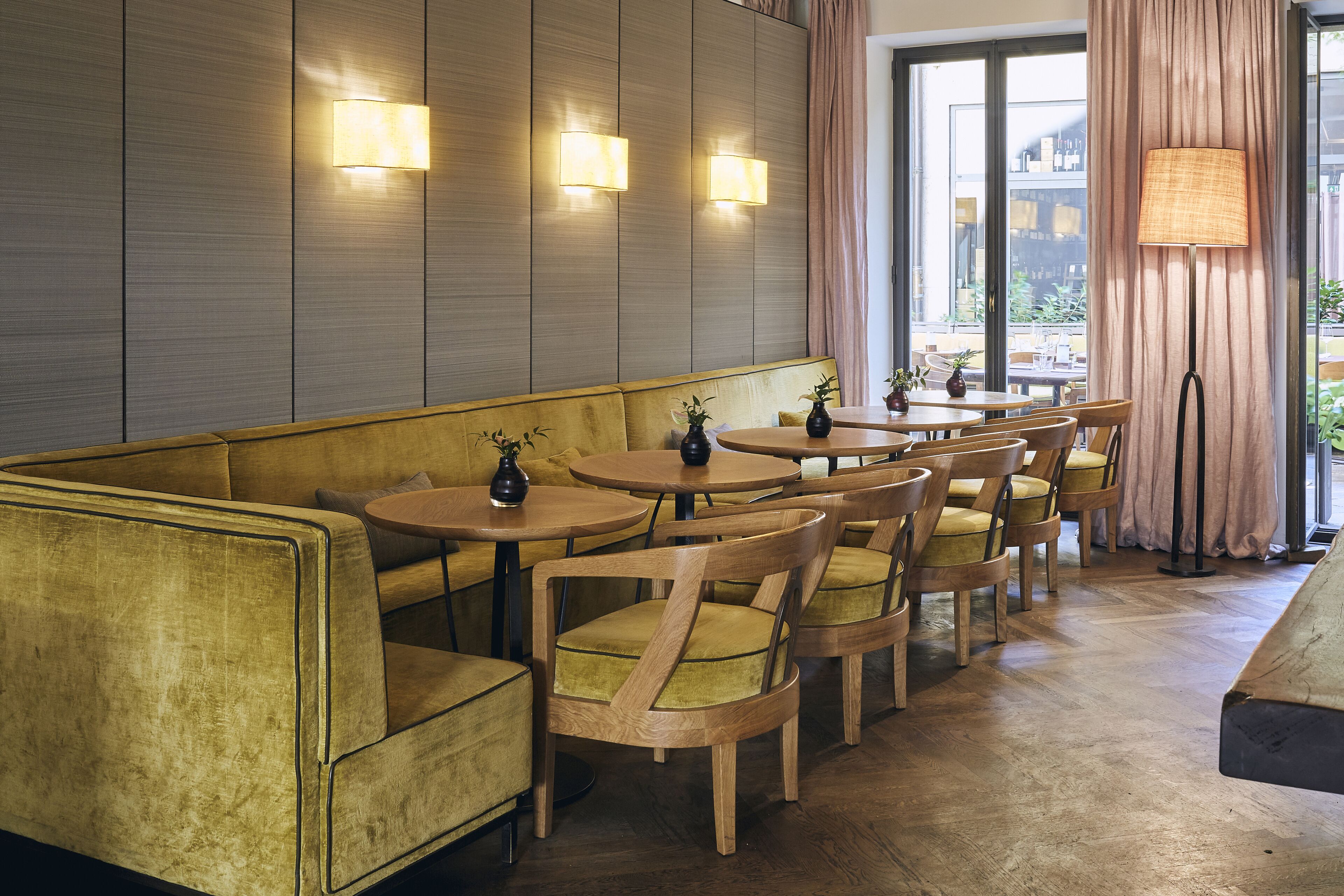 Interior de restaurante com uma extensa área de bancos, mesas e cadeiras de madeira.