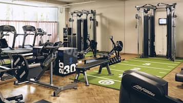 A gym with treadmills, weight machines, and a green turf area.