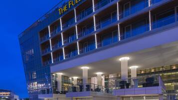 The Fullerton Bay Hotel with a waterfront view, multiple balconies, and a modern architectural design.