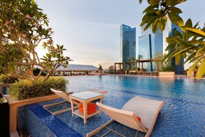 Una piscina al aire libre, tumbonas