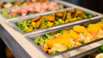 Un bufé con diversos platos, incluyendo mariscos, verduras y frutas.