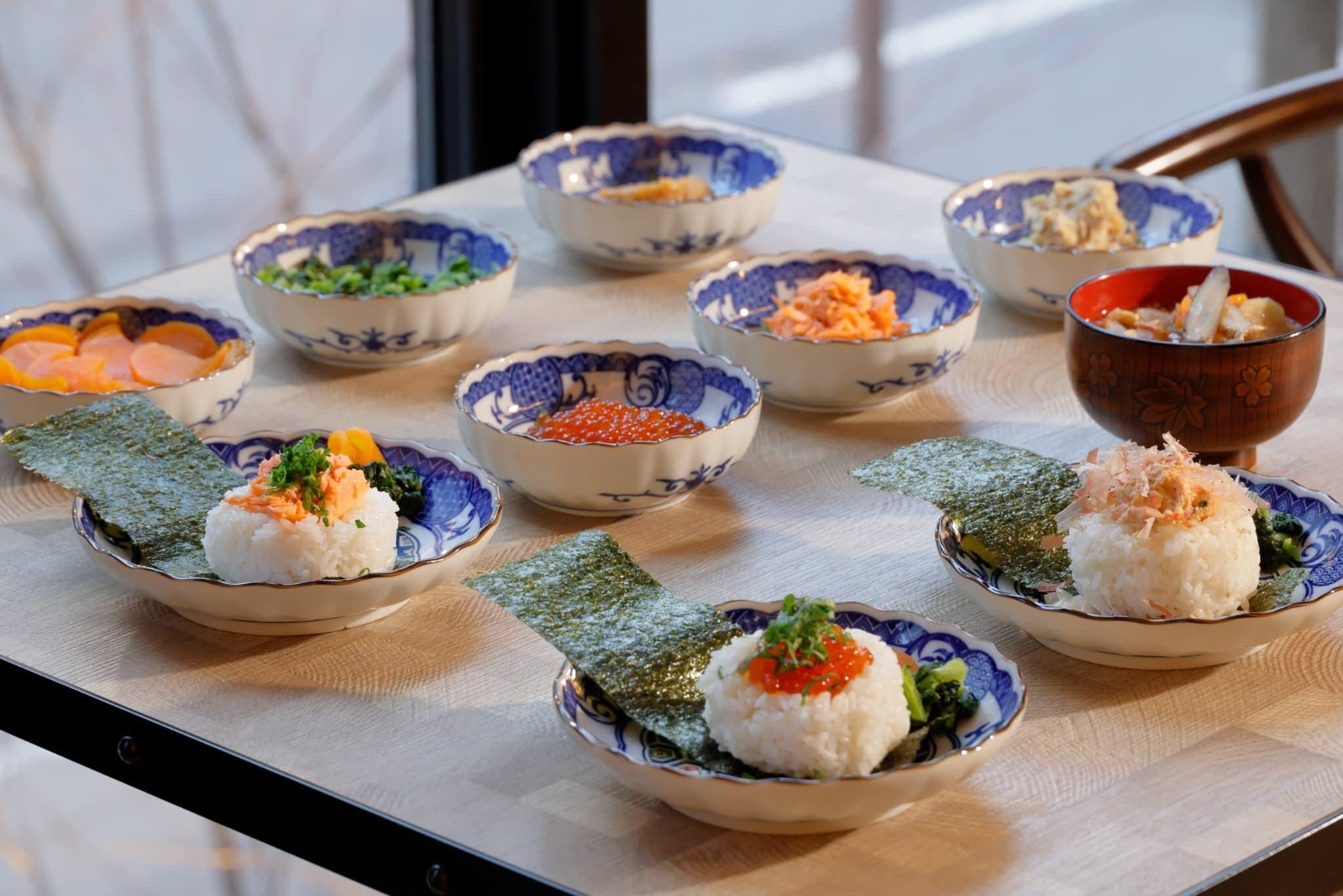 A table with various bowls of Japanese cuisine, including rice and vegetables.