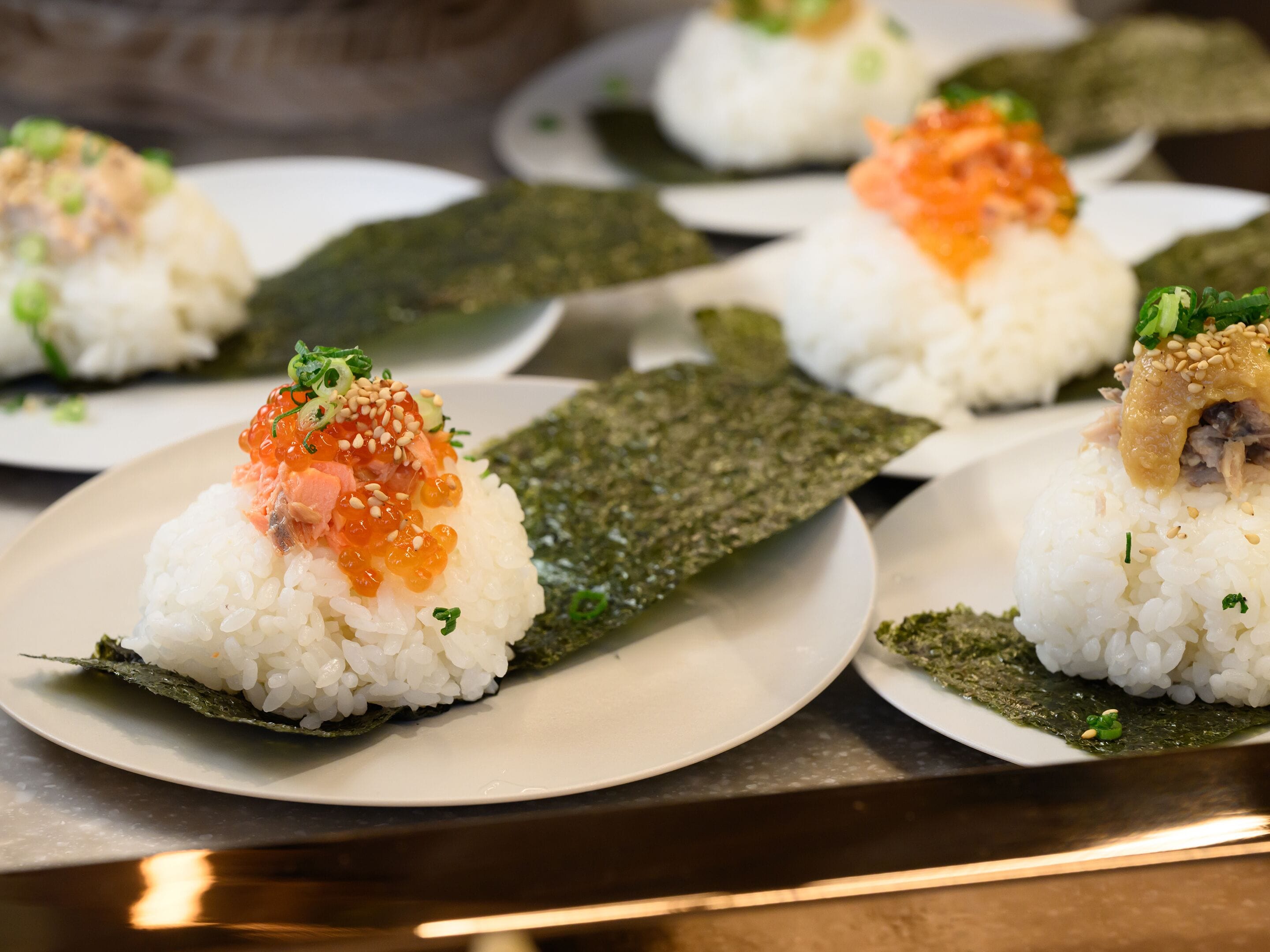 Un plato de sushi con arroz, pescado y alga marina.