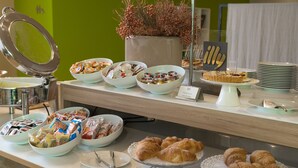 A buffet with various food items including pastries, fruits, and a cake. - Helios Hotel Monza (Monza)