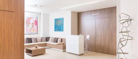 A modern hotel lobby with a reception desk, a sofa, and a coffee table.