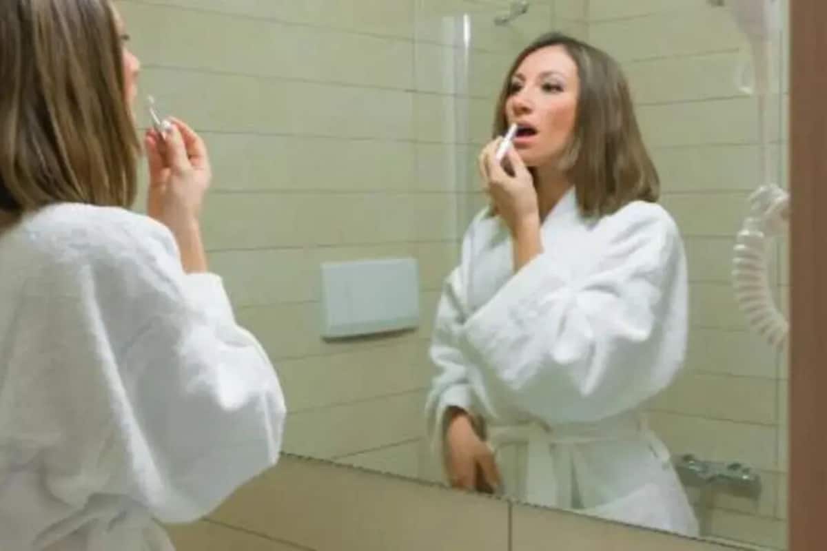 Une salle de bain avec un miroir, un lavabo et un porte-serviettes.
