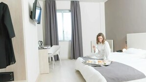 A modern hotel room with a bed, a desk, and a television. - Helios Hotel Monza (Monza)