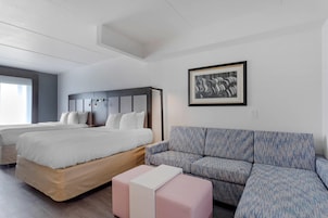 Una habitación de hotel moderna con una cama grande, un sofá y una pequeña mesa.