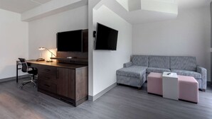 Un dormitorio moderno con escritorio, silla y una cama grande.