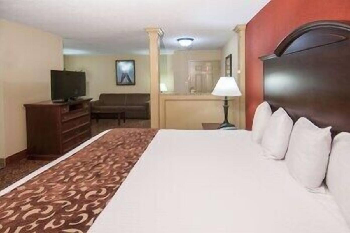 A hotel room with a bed, a television, a desk, and a chair.