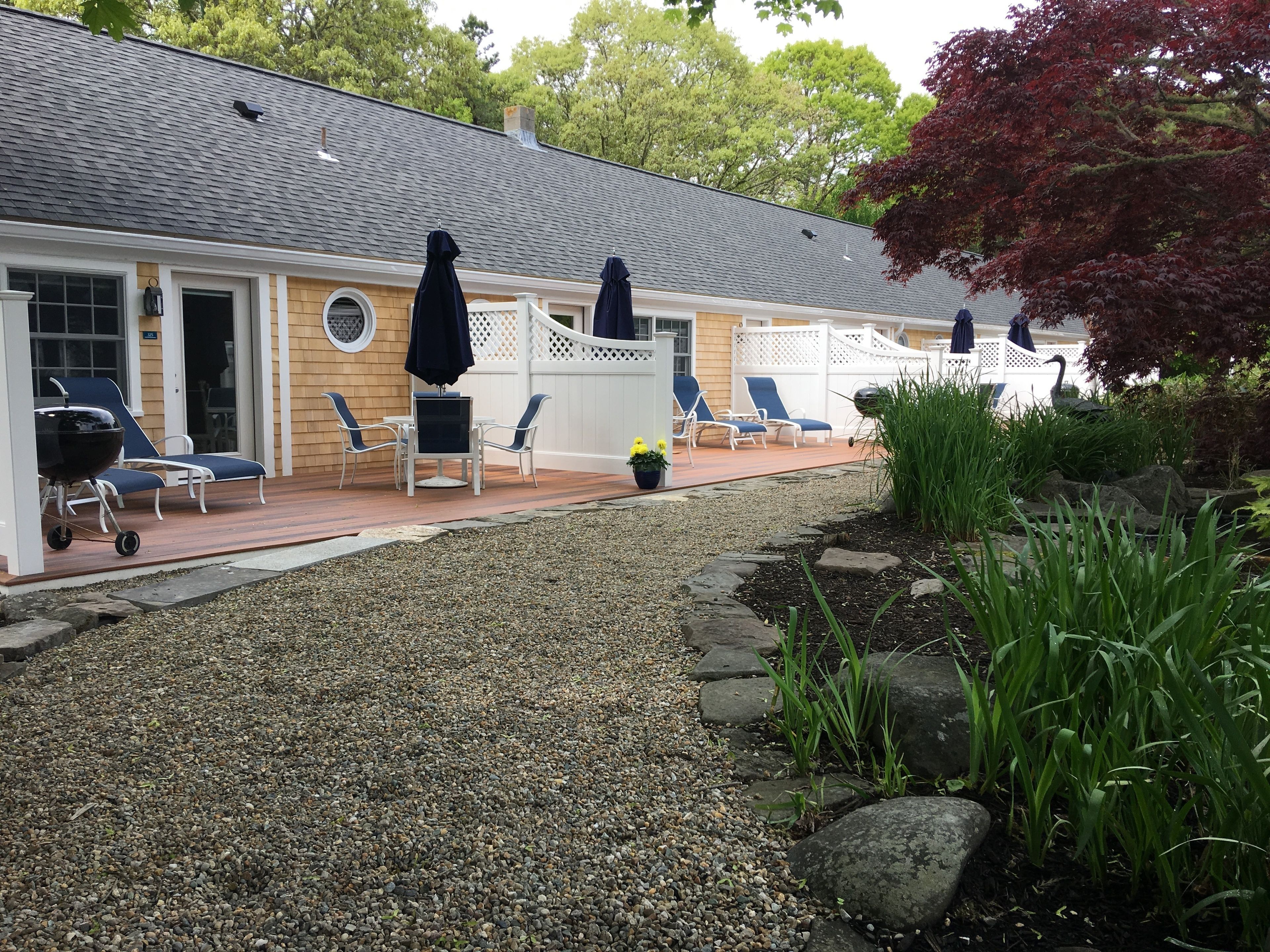 Una spa con area relax all'aperto, patio coperto e giardino con rocce e piante.