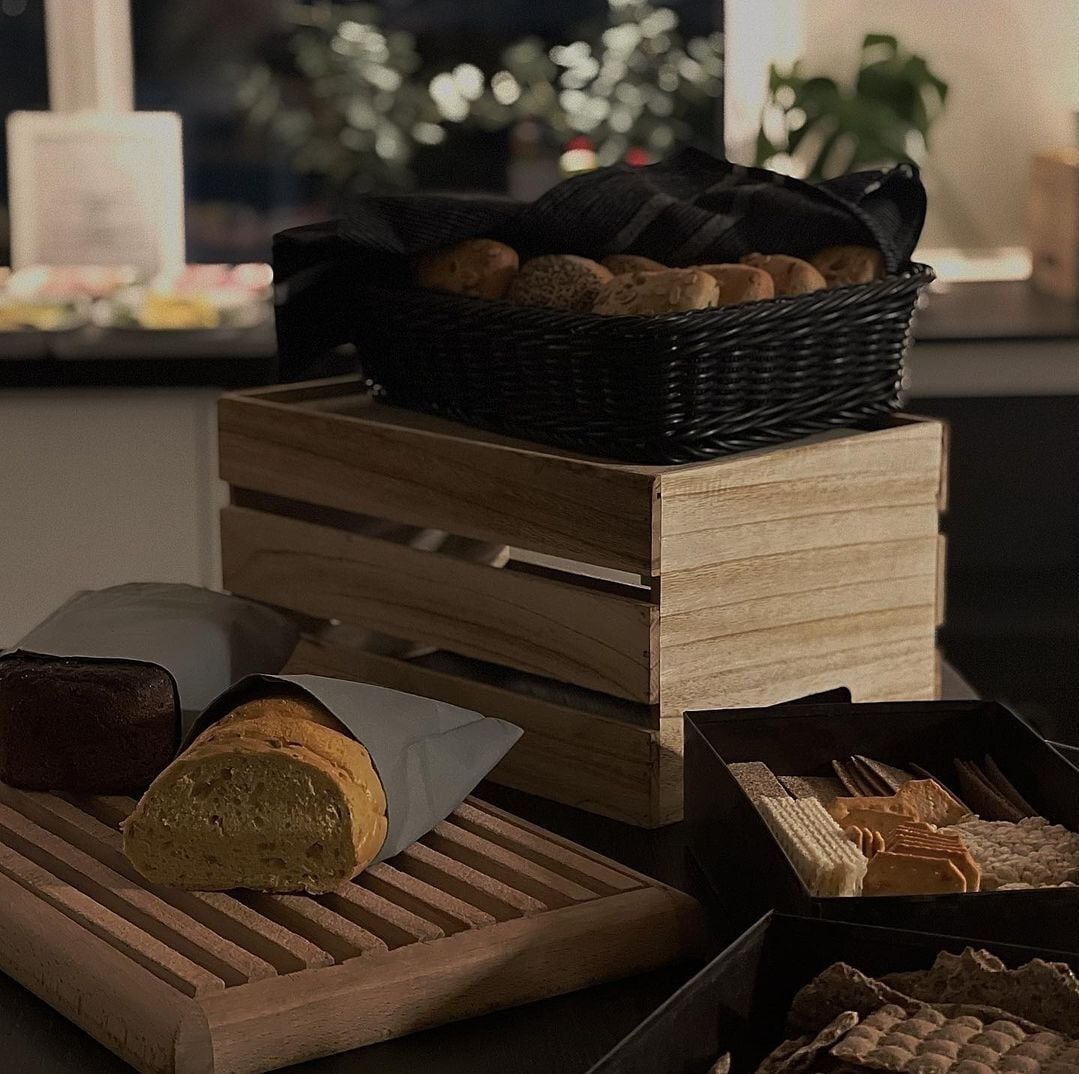 A wooden crate with a basket of bread and pastries on top.