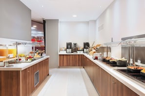 A modern breakfast bar with a variety of food options, including fruits, cereals, and beverages.