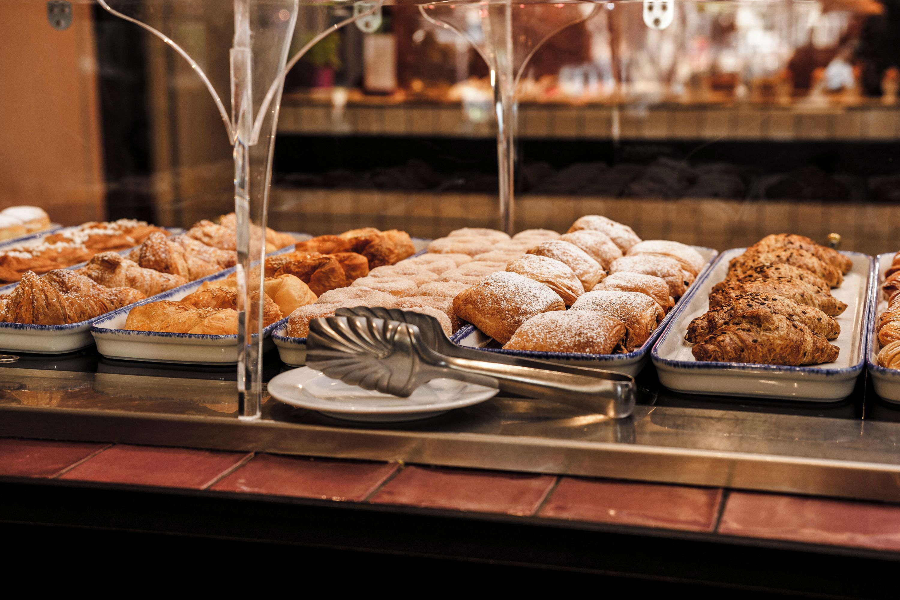 Una vetrina di pasticceria con diversi dolci e un cucchiaio da portata.