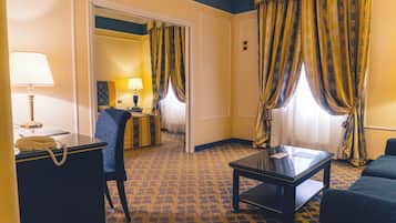 Una habitación de hotel con una cama, un escritorio con teléfono, una silla, una mesa y cortinas.