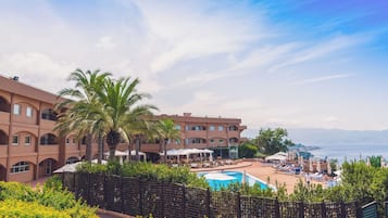 Ein Resort mit Pool, Palmen und Meerblick.