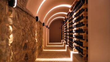 A wine cellar with a stone wall and a wooden wine rack.