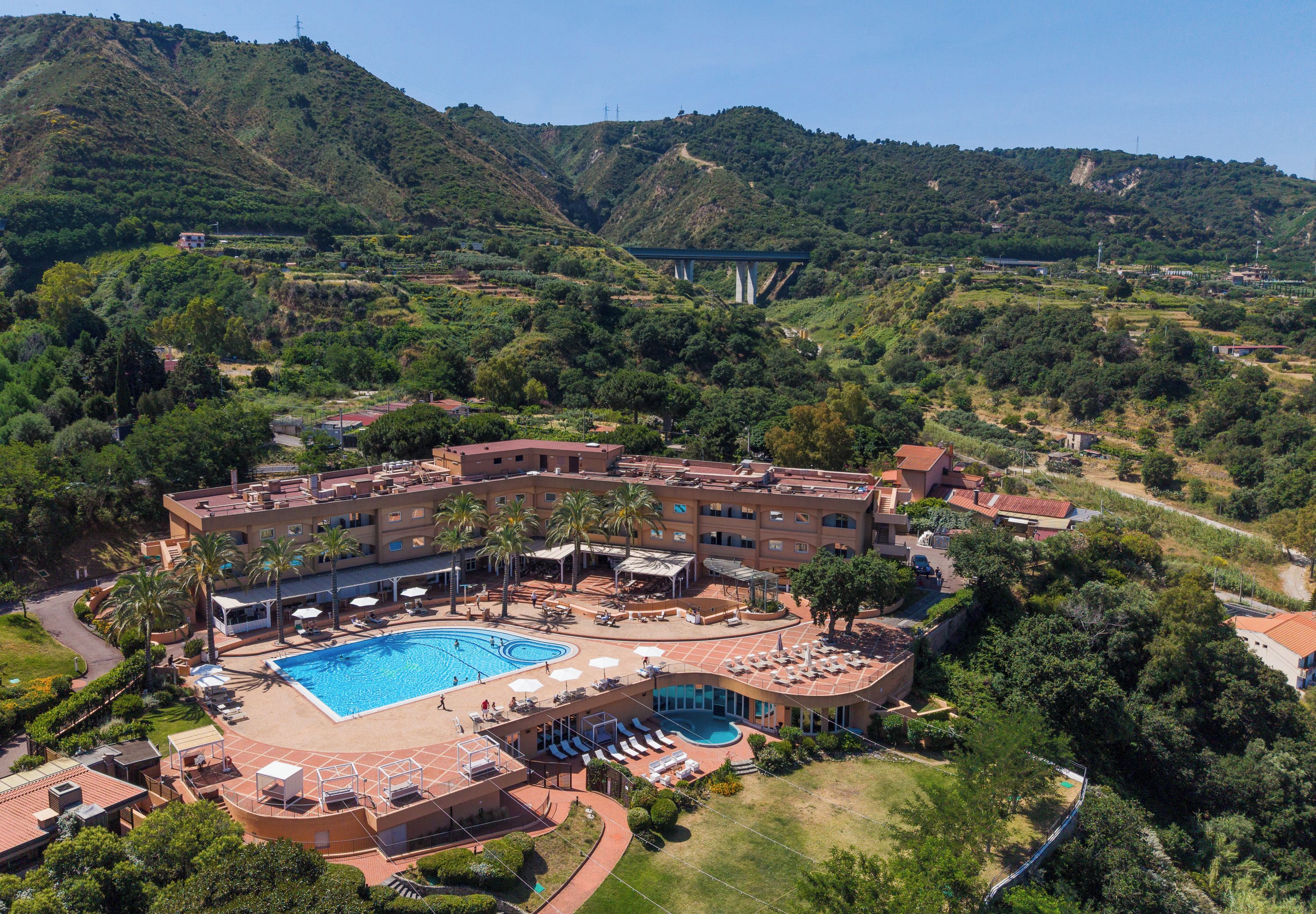 Un hôtel doté d’une piscine, de plusieurs espaces de détente et offrant une vue sur un paysage montagneux.