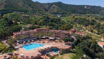 Un hôtel doté d’une piscine, de plusieurs espaces de détente et offrant une vue sur un paysage montagneux.