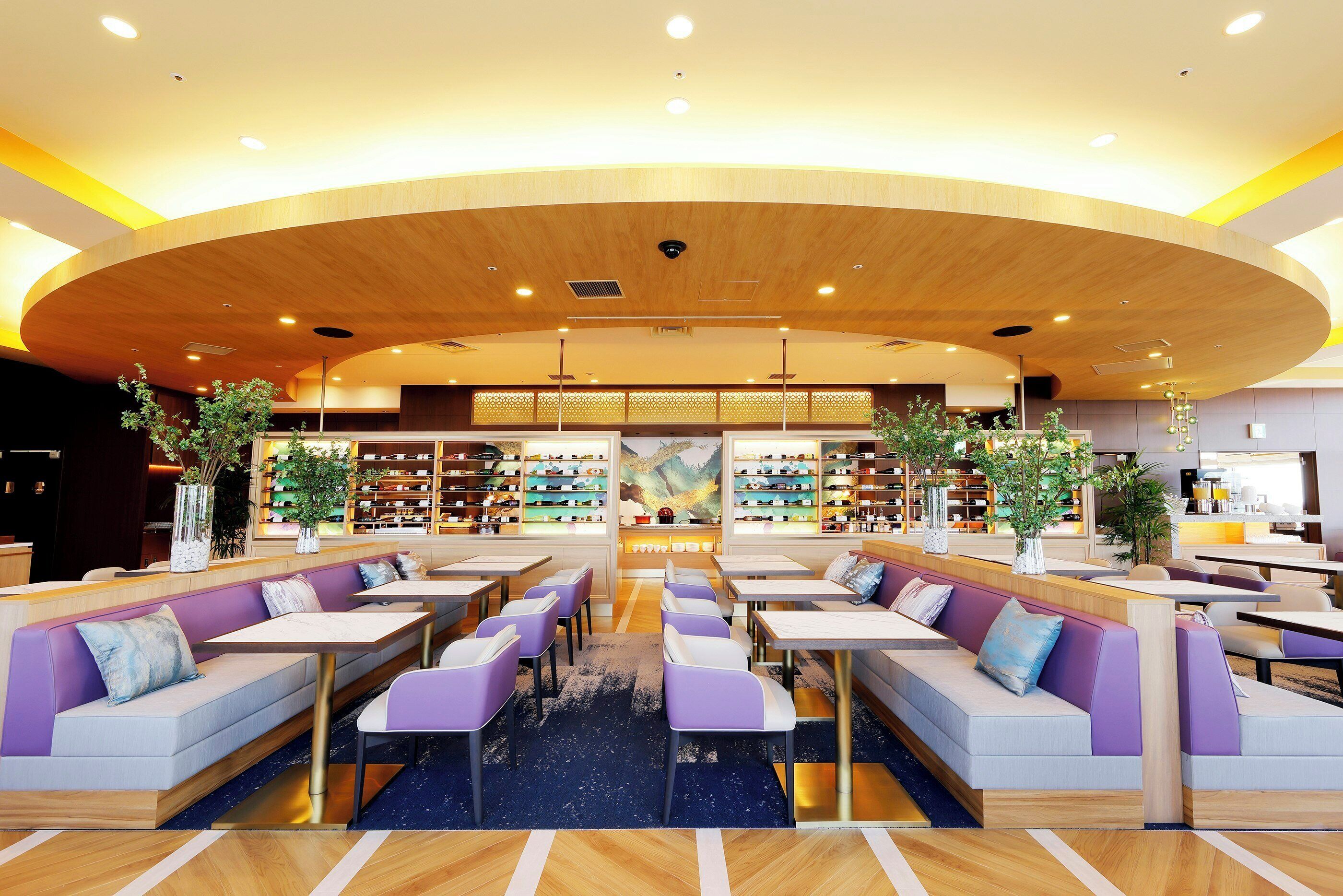 A modern interior with seating areas, a central display, and a variety of bookshelves.