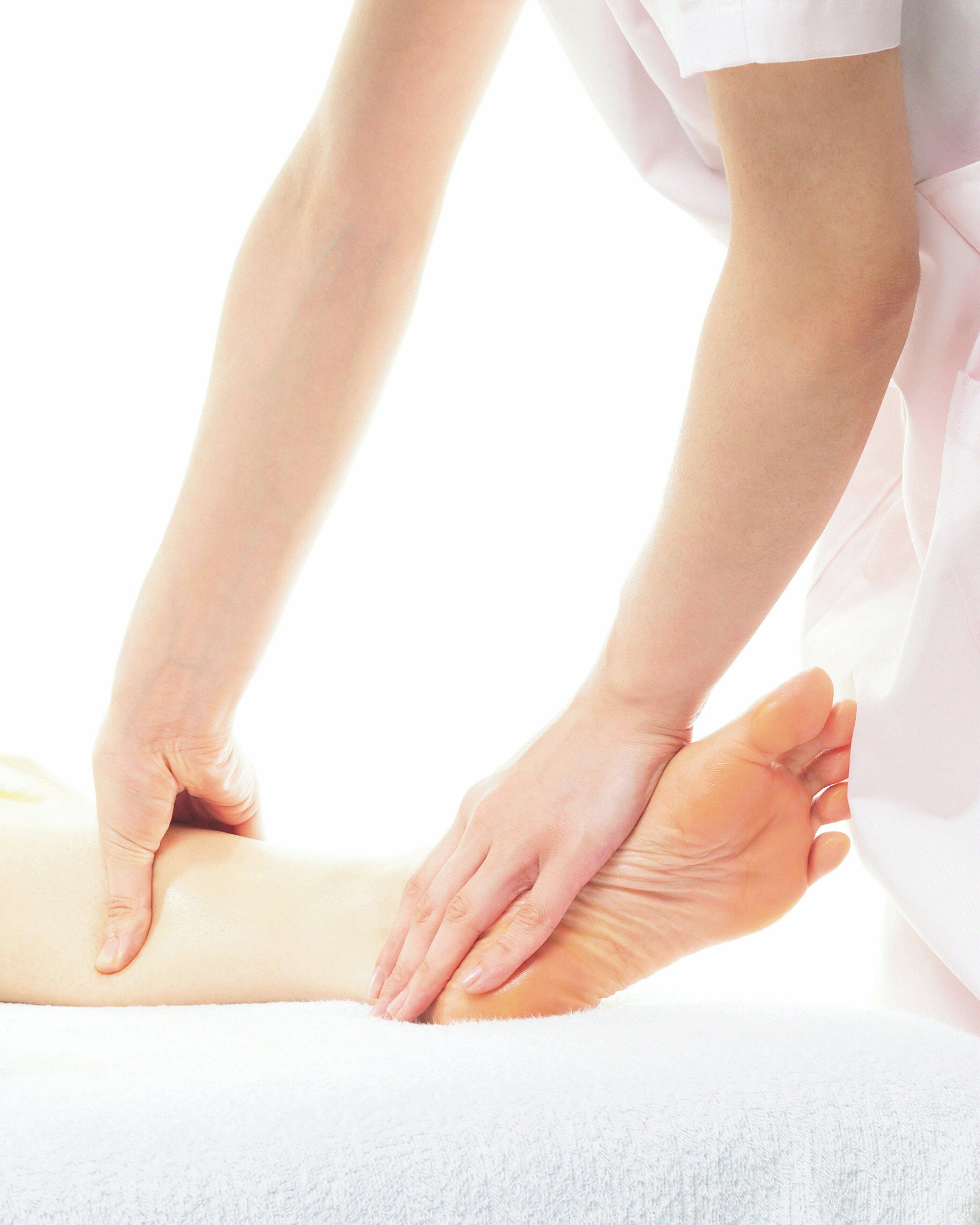 A close-up of hands performing a massage on a leg.