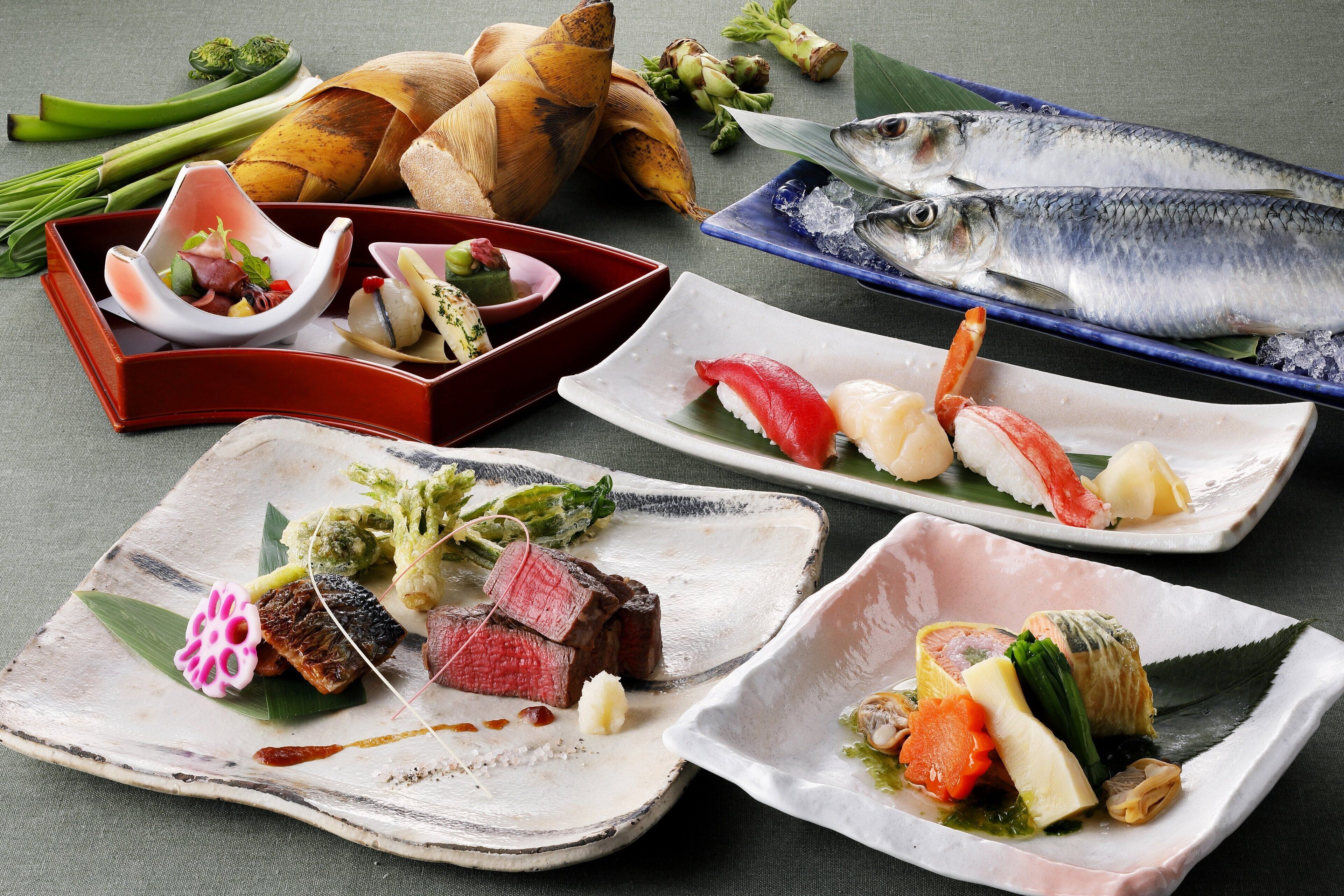 A variety of dishes including sushi, sashimi, and grilled meat, arranged on different plates and bowls.