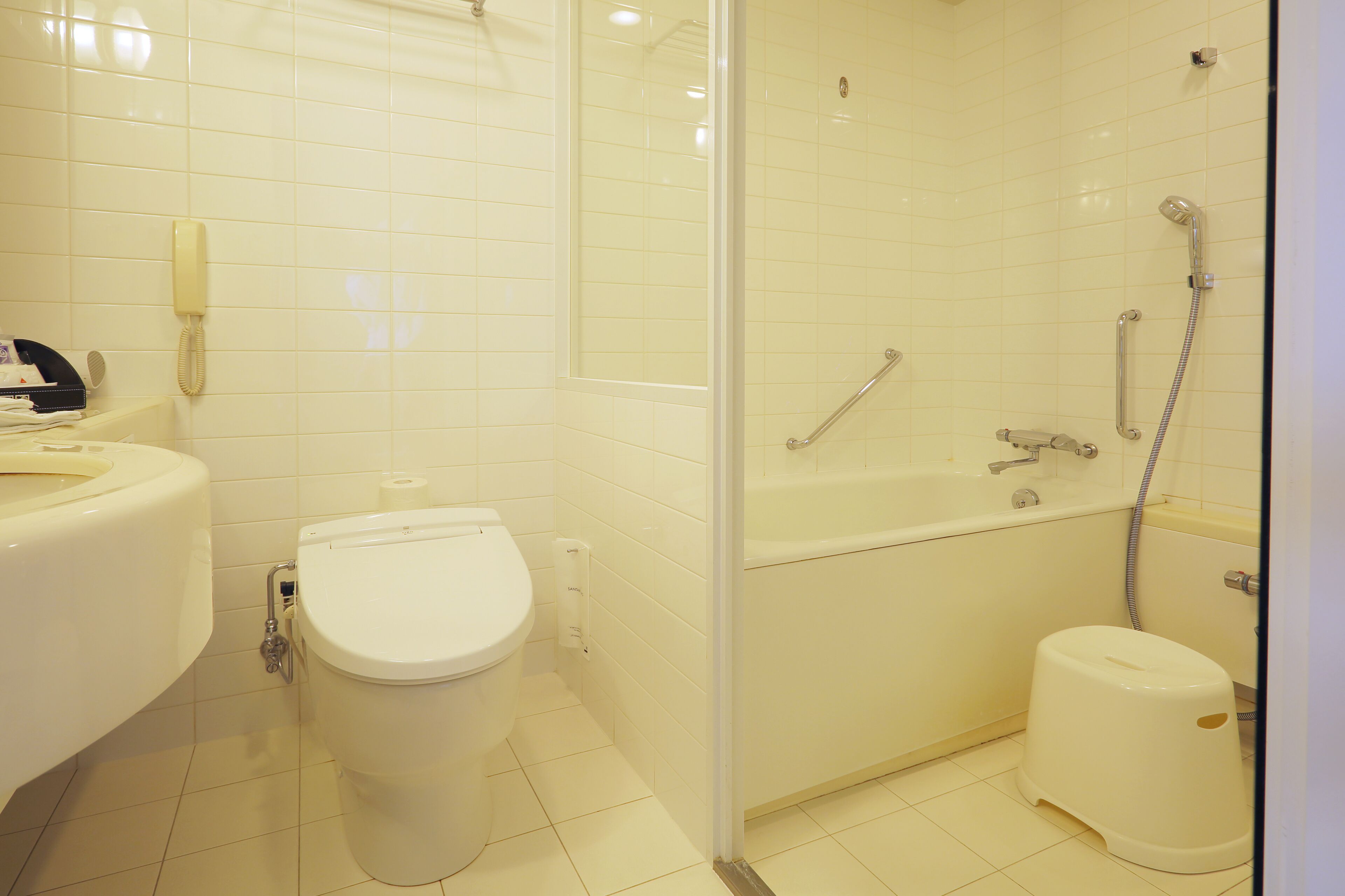 A bathroom with a toilet, sink, and shower area.