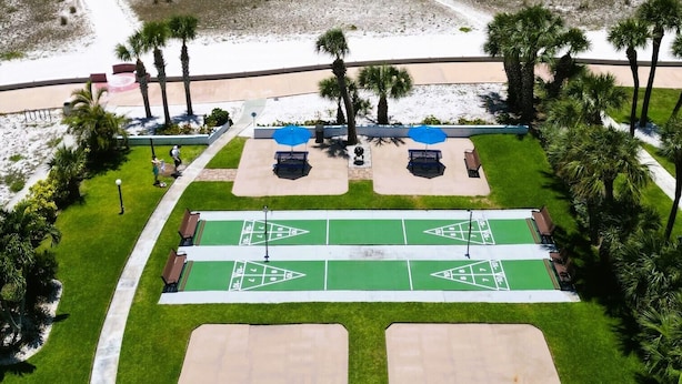 A beachside resort with a parking area, shuffleboard courts, and a view of the ocean. - Beachside Resort Motel (Treasure Island)