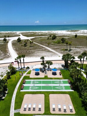 Un resort frente al mar con estacionamiento, canchas de juego de hojalata y vistas al océano.