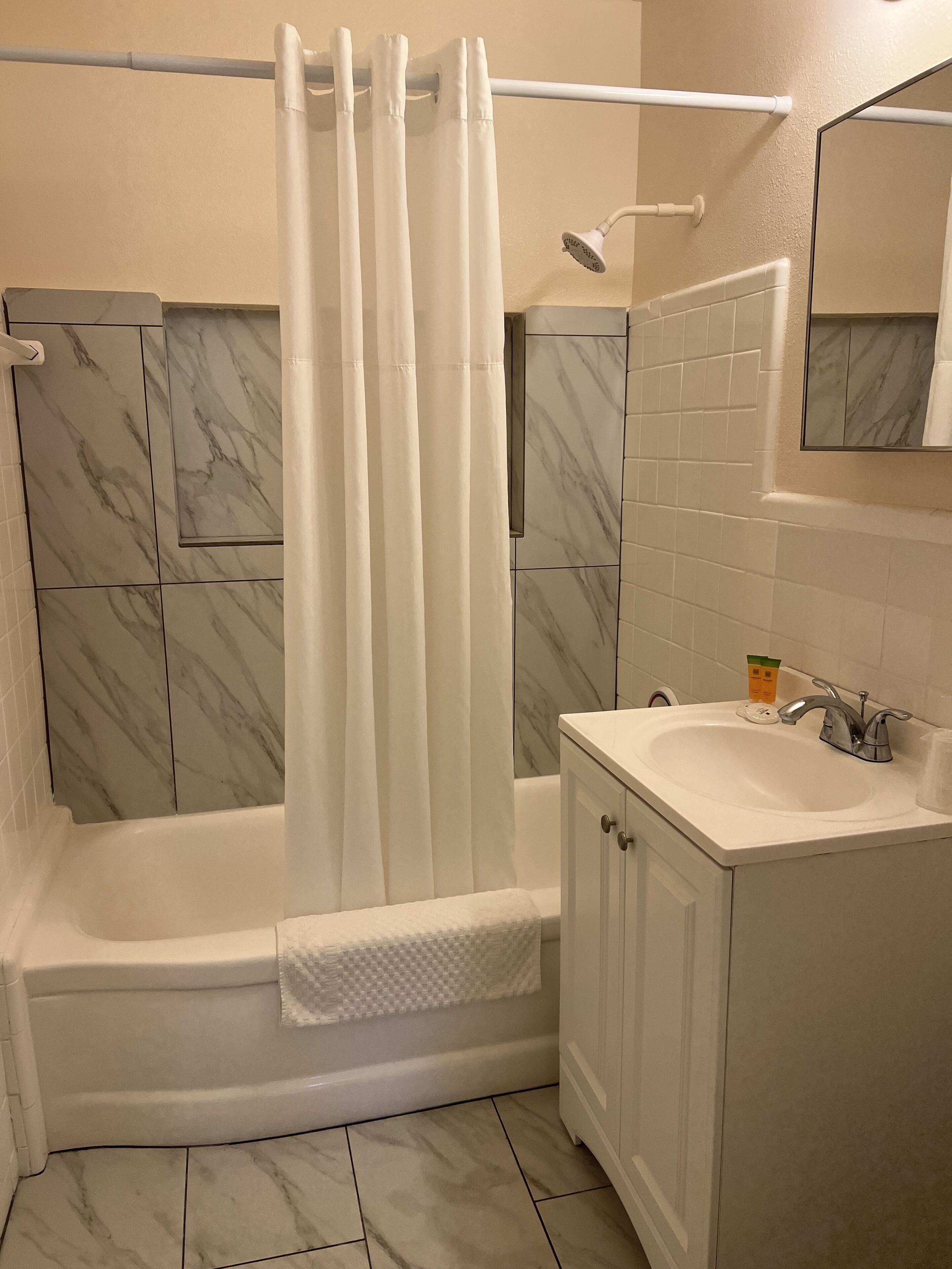 Un baño con bañera, ducha y lavamanos.