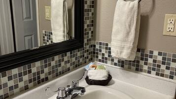 Un baño con lavamanos blanco, un espejo y salpicadero de azulejos.