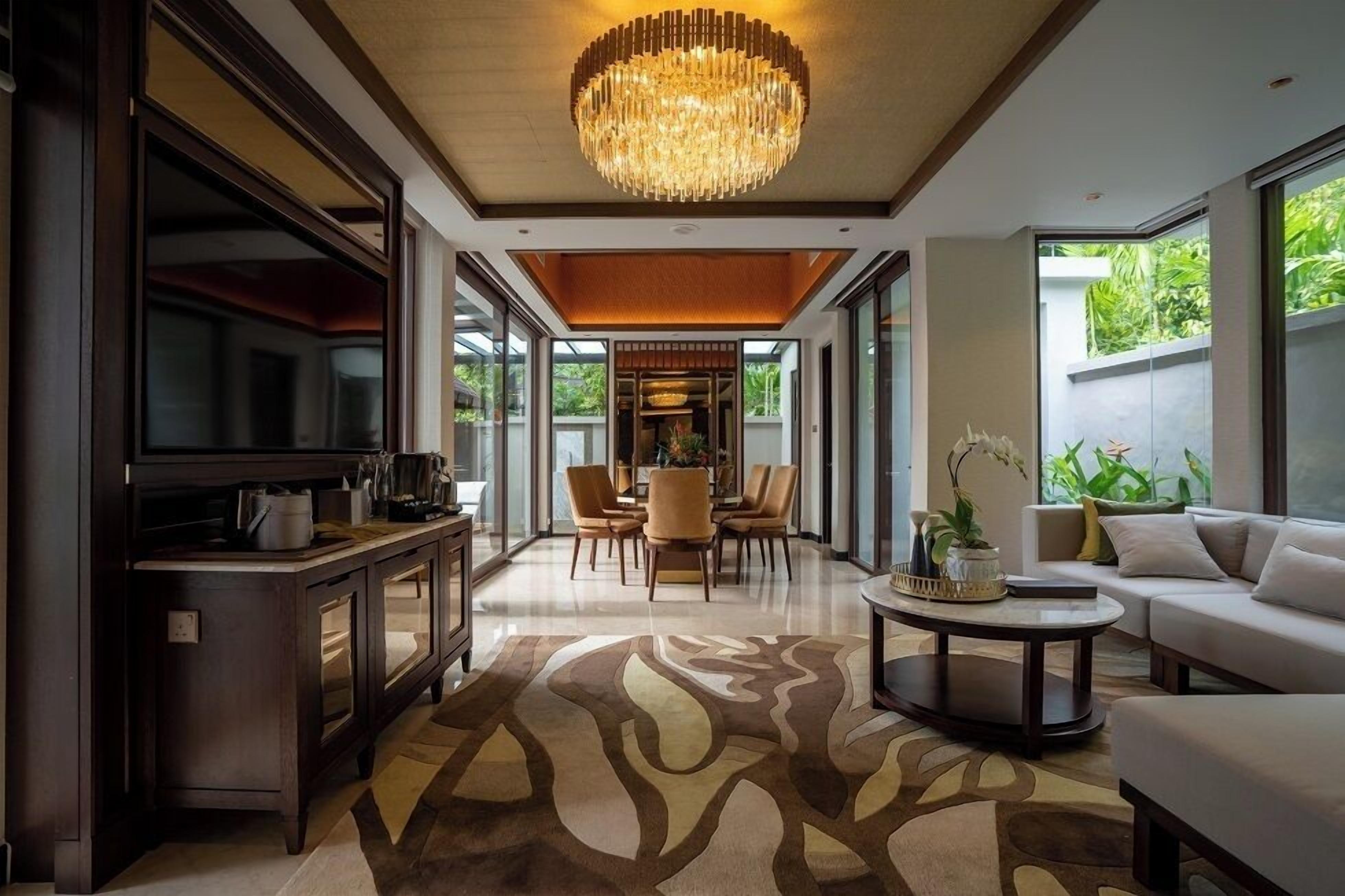 Uma sala de estar moderna com um candelabro, uma área de jantar e um sofá.