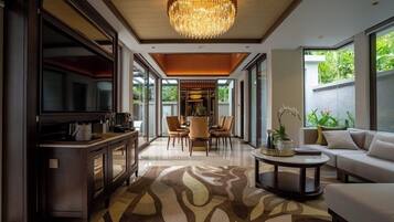 Uma sala de estar moderna com um candelabro, uma área de jantar e um sofá.