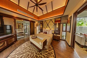 A modern hotel room with a large bed, a television, a desk, and a view of the outdoors.