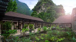 A traditional building with a covered walkway and a pond with water lilies. - The Banjaran Hotsprings Retreat (Ipoh)