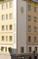 A multi-story hotel building with a vertical sign reading "HOTEL NAPLES."