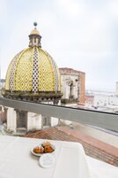 Un tavolo con pasticcini e una targa d'hotel, con vista su un edificio storico con una cupola decorata.