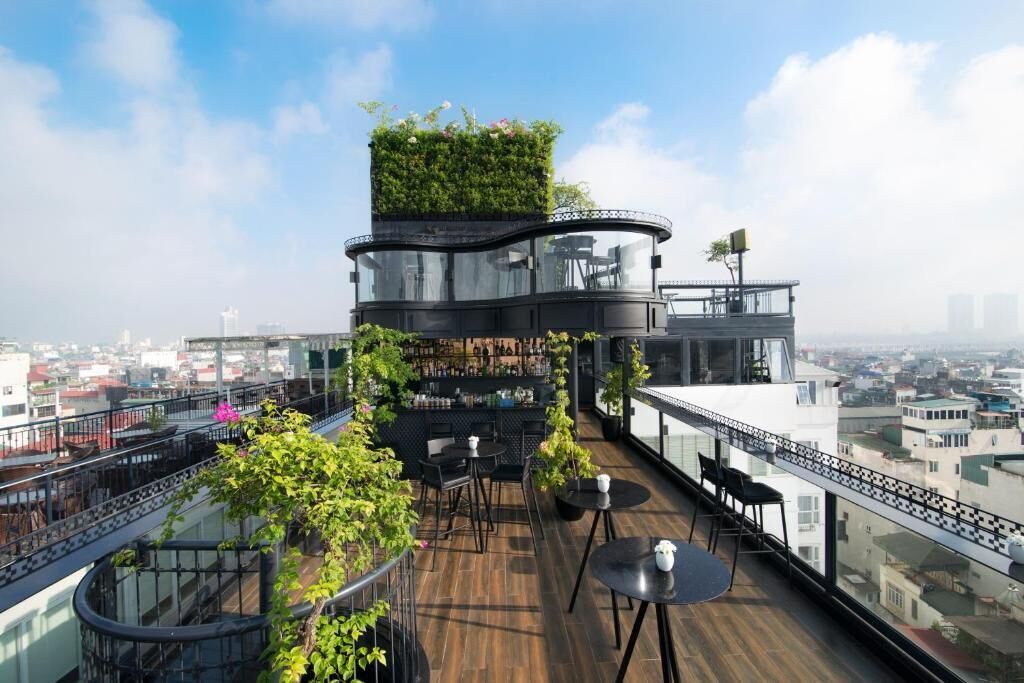 A rooftop terrace with a bar area, seating, and a vertical garden.