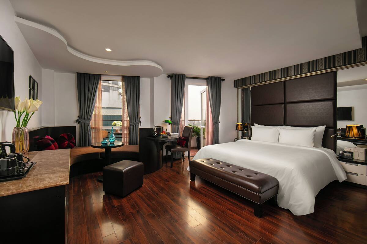 Une chambre d’hôtel moderne, dotée d’un grand lit, d’un bureau, d’un canapé et d’une petite table.