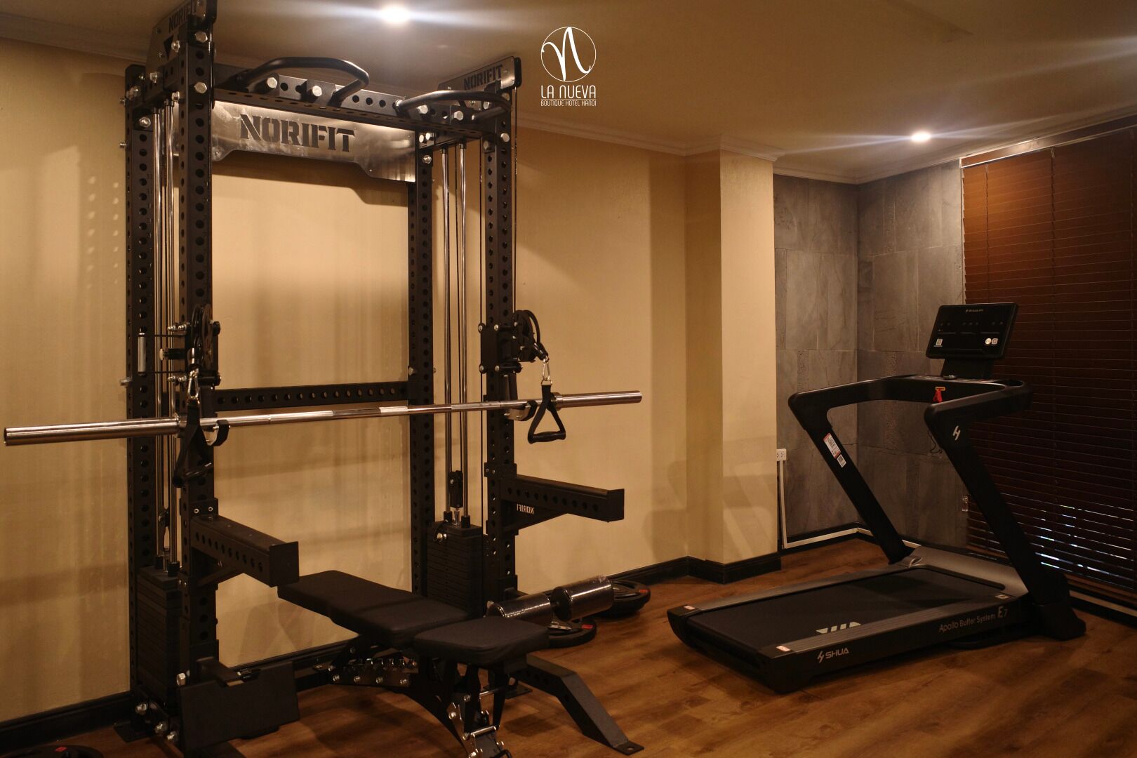 A gym with a NorriFit squat rack, a bench, and a treadmill.