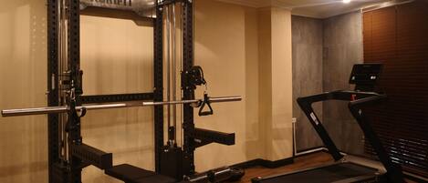 A gym with a NorriFit squat rack, a bench, and a treadmill.