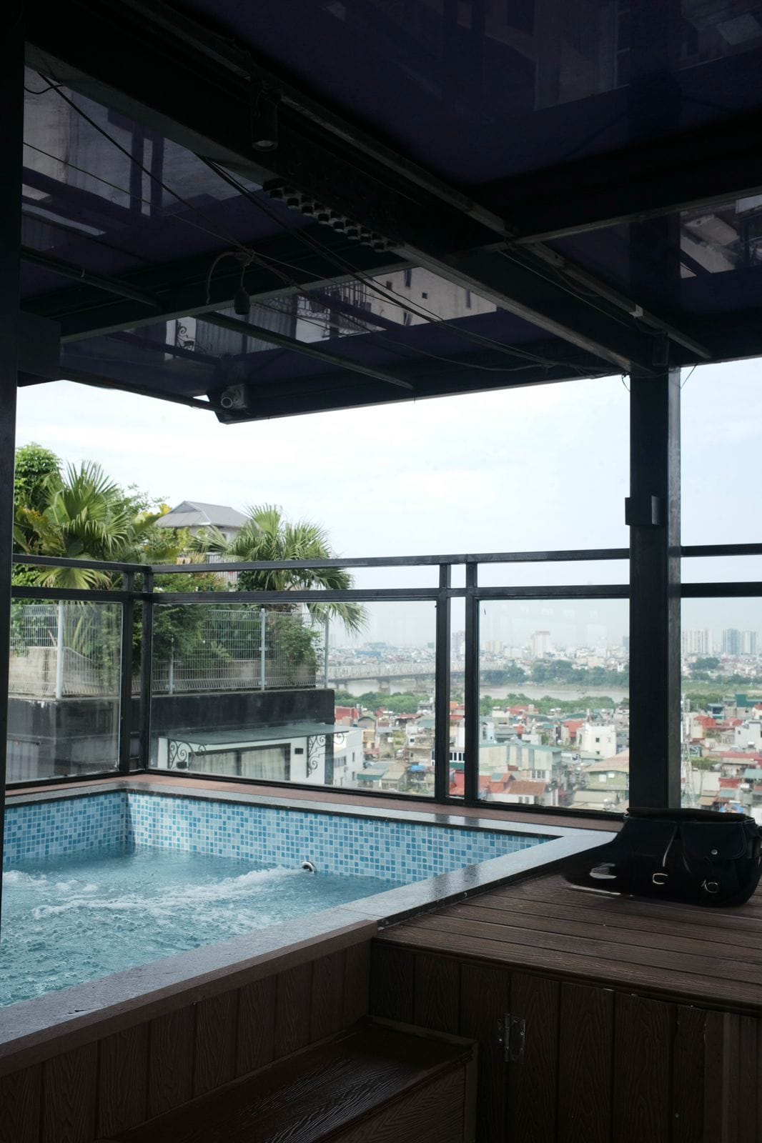 Una piscina en la azotea con vistas a un paisaje urbano.