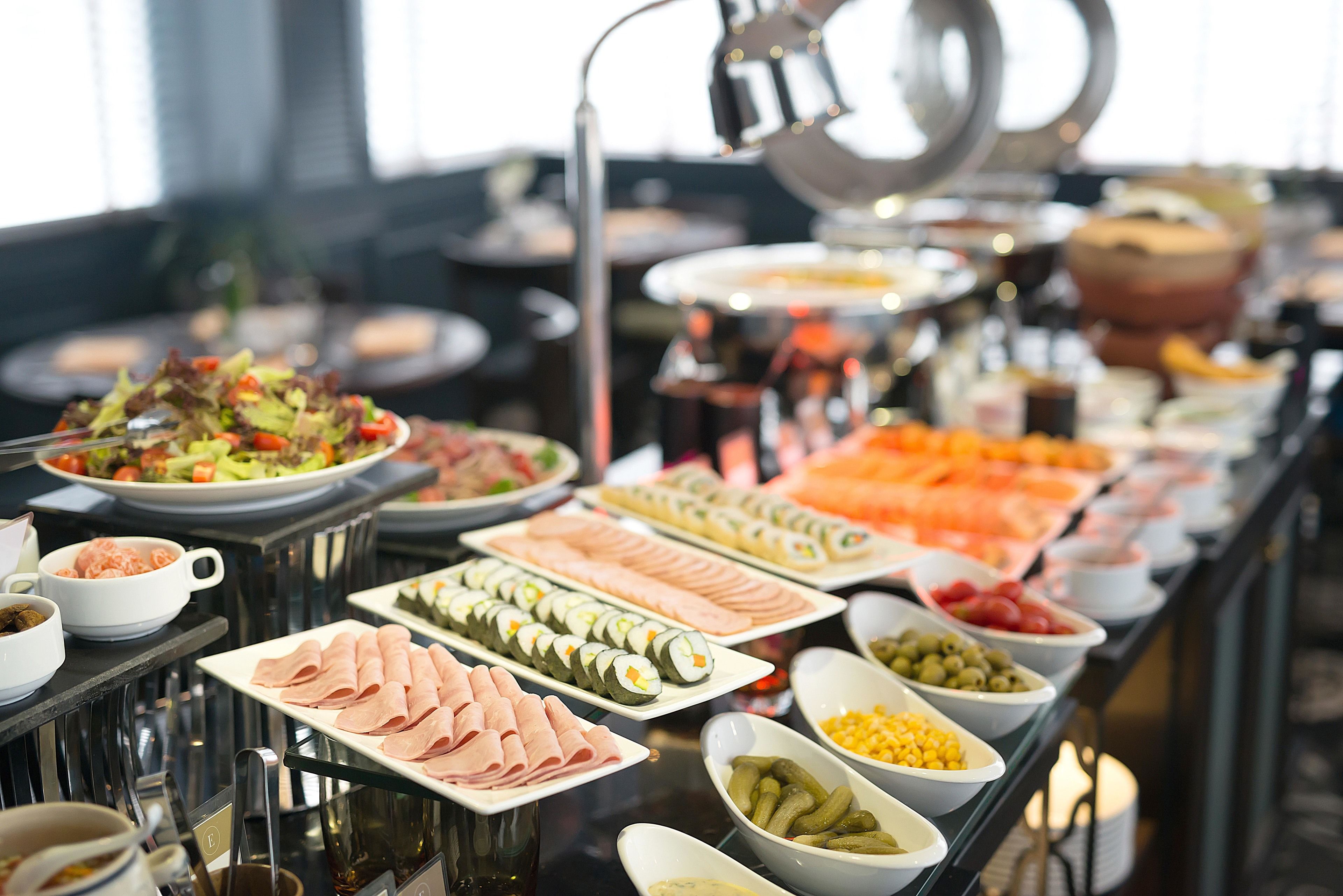 A buffet with various food items including sushi, meats, and vegetables.